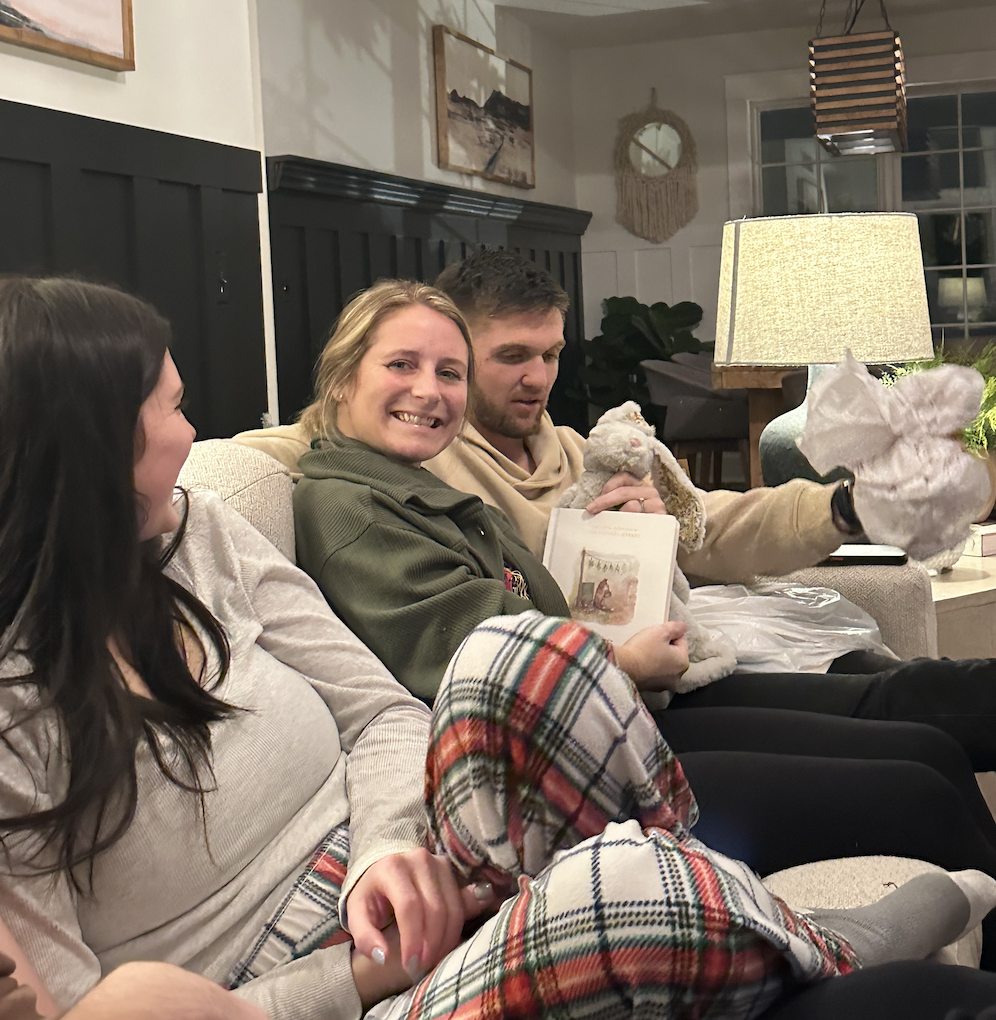 3 people sitting on the sofa talking and laughing.